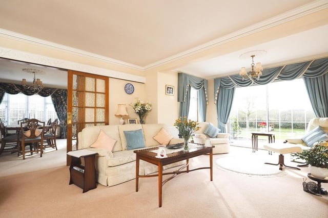 The first reception room to inspect is this bright and beautiful lounge, the largest room in the bungalow. French doors lead to the dining room, and the imposing window overlooks the back garden, river, bridge and all.