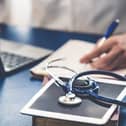 Stock image of a doctor writing in a notepad.