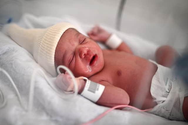 A new-born baby lies in an incubator moments after her birth at a maternity ward (Photo by CHRISTOPHE ARCHAMBAULT/AFP via Getty Images)