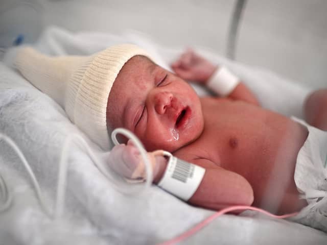 A new-born baby lies in an incubator moments after her birth at a maternity ward  (Photo by CHRISTOPHE ARCHAMBAULT/AFP via Getty Images)