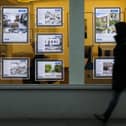 File photo of a pedestrian walking past an estate agents