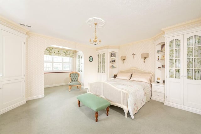 The principal bedroom has views of the garden, fitted wardrobes and an en suite bathroom