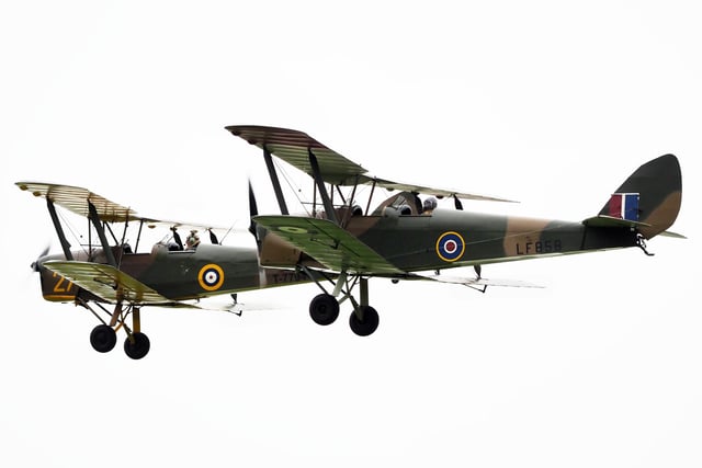 A pair of Tiger Moths fly past