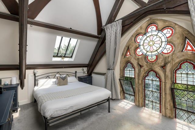 The master bedroom offers a number of original features with stained glass windows as a stunning backdrop.