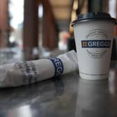 A Greggs disposable coffee cup and sausage roll on a table. (Photo illustration by Christopher Furlong/Getty Images)