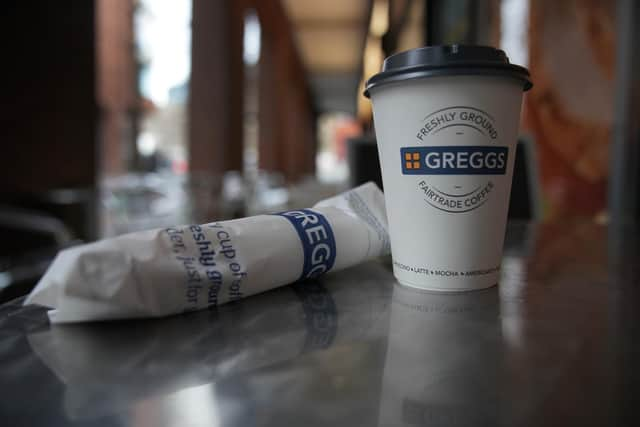 A Greggs disposable coffee cup and sausage roll on a table. (Photo illustration by Christopher Furlong/Getty Images)