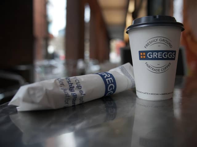 A Greggs disposable coffee cup and sausage roll on a table. (Photo illustration by Christopher Furlong/Getty Images)