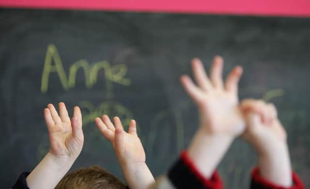 Children wave their hands at a nursery school. Picture: Christopher Furlong/Getty Images