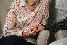 Care home resident holds hands with her daughter. Picture: Andrew Matthews/PA.