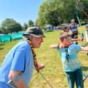 Scout volunteer Pete teaches a Cub Scout Archery