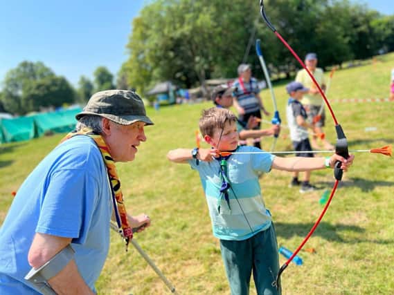 Scout volunteer Pete teaches a Cub Scout Archery