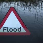 A flood warning road sign on a partially submerged road (Photo by Oli Scarff/Getty Images)