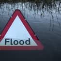 A flood warning road sign on a partially submerged road (Photo by Oli Scarff/Getty Images)