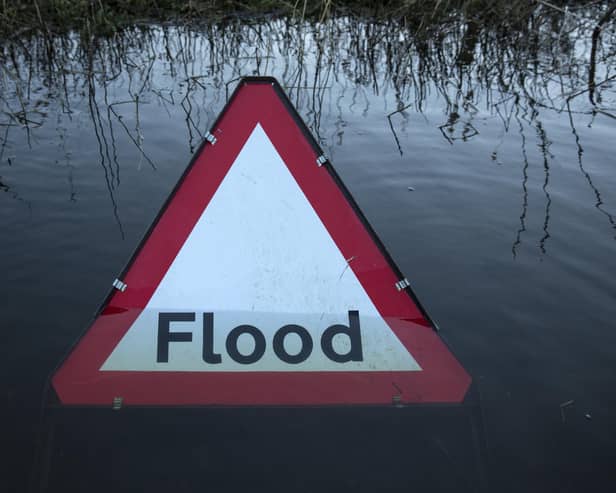 A flood warning road sign on a partially submerged road (Photo by Oli Scarff/Getty Images)