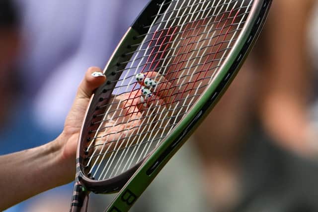 Close up of a person holding a tennis racket (Photo by SEBASTIEN BOZON/AFP via Getty Images)