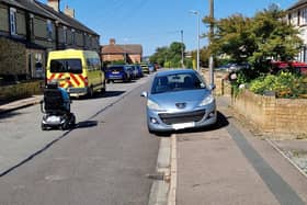Image shows a mobility scooter user forced on to the road by a car parked on the pavement