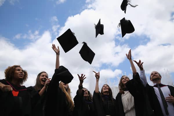 Students throw their caps in the air ahead of their graduation ceremony.  (Photo by Dan Kitwood/Getty Images)
