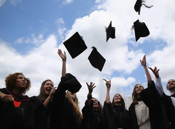 Students throw their caps in the air ahead of their graduation ceremony.  (Photo by Dan Kitwood/Getty Images)