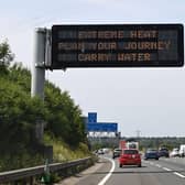 A road sign reads "Extreme Heat, Plan your journey, Carry water", warning motorists about the heatwave forecast for July 18 and 19 (Photo by Damien MEYER / AFP)