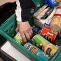A member the public looks through food items inside a foodbank (Photo by DANIEL LEAL/AFP via Getty Images)