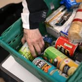 A member the public looks through food items inside a foodbank (Photo by DANIEL LEAL/AFP via Getty Images)
