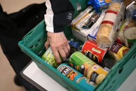 A member the public looks through food items inside a foodbank (Photo by DANIEL LEAL/AFP via Getty Images)