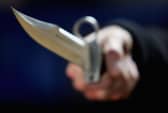 A hunting knife is held by an employee at a film and television prop company. Photo by Ian Waldie/Getty Images