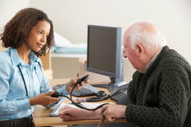 File photo of a doctor taking a man's blood pressure