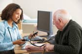 File photo of a doctor taking a man's blood pressure