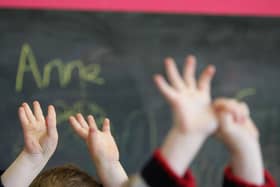 File photo of children raising their hands in class (Photo by Christopher Furlong/Getty Images)
