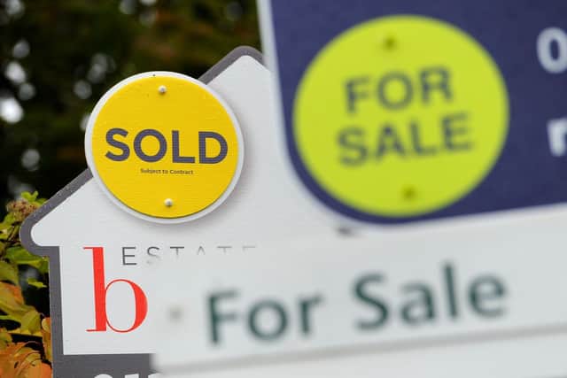 File photo of a sold and for sale signs.