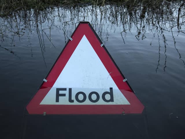 A flood warning road sign on a partially submerged road (Photo by Oli Scarff/Getty Images)