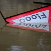 A flood warning sign lies in the water following heavy rain. (Pic credit: Leon Neal / Getty Images)