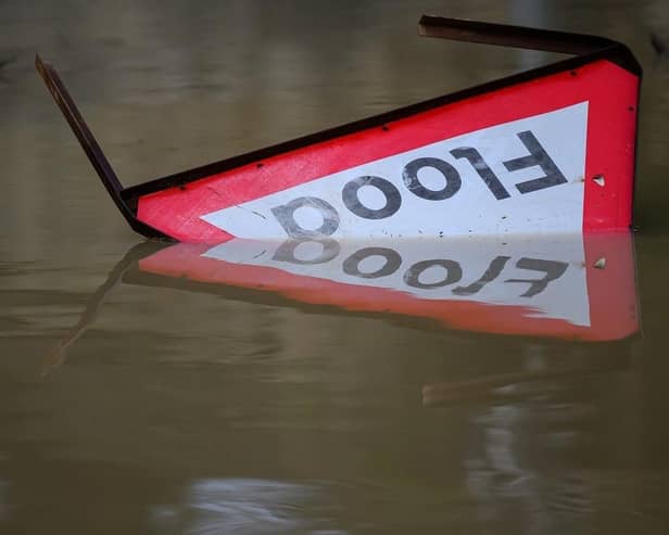 A flood warning sign lies in the water following heavy rain. (Pic credit: Leon Neal / Getty Images)