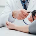 Doctor checking blood pressure of a patient, he is measuring pulses with a sphygmomanometer, hands close up