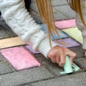 A child drawing on the street with chalk