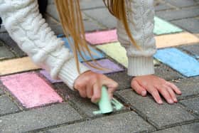 A child drawing on the street with chalk