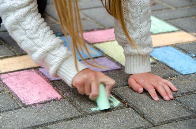 A child drawing on the street with chalk