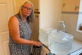 An Everton resident fills up her kettle from a water container. Credit: Cllr Les Alexander.