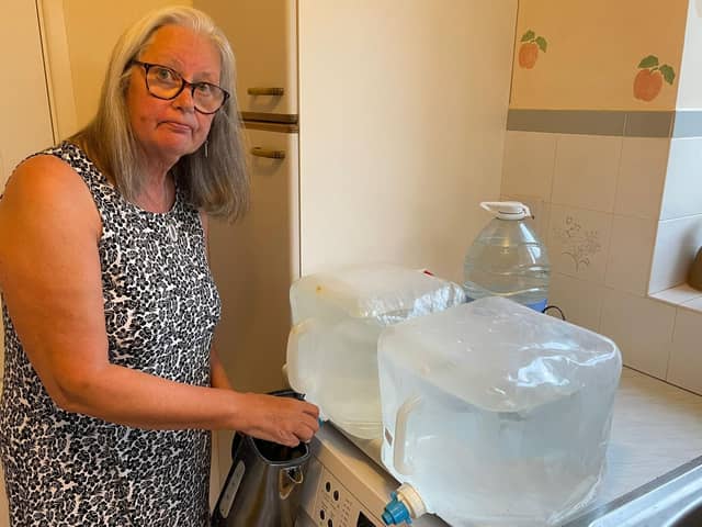 An Everton resident fills up her kettle from a water container. Credit: Cllr Les Alexander.