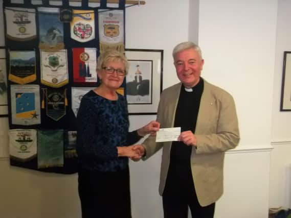Rev Guy Scott receives a cheque from Barbara Hazell, president of Biggleswade Rotary, for the St Andrew's Parish Fund