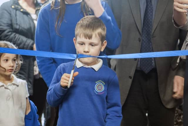 Gamlingay Village Primary pupil Jack Page leads the ribbon cutting ceremony.