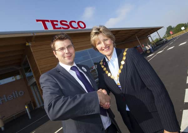 Dave Harwood, store manager of Tesco in Sandy, gives £250 to Councillor Maudlin