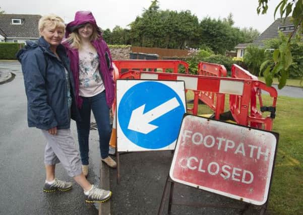 Christine Hobart waiting for a hole to be filled in outside her house, it's been there for four months, pictured with her daughter Charlotte