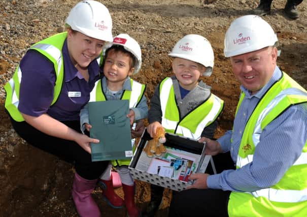 Four-year-olds Jessica Schneibner and Reece Stafferton prepare to bury the time capsule