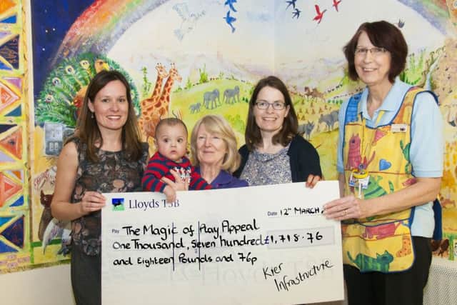 Kier employees Jessica Plocins and Claire Lepoutre present the cheque to Lister Hospital staff after the bear baton challenge.