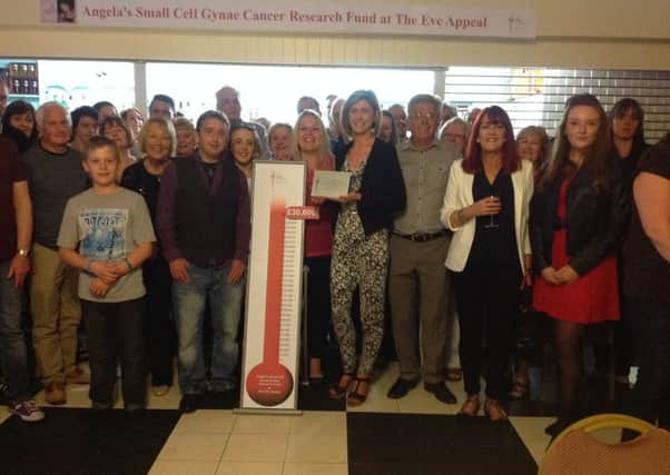 Becca Braithwaite with the special plaque (right of the £30,000 thermometer), surrounded by Angela Butchers family and friends.
