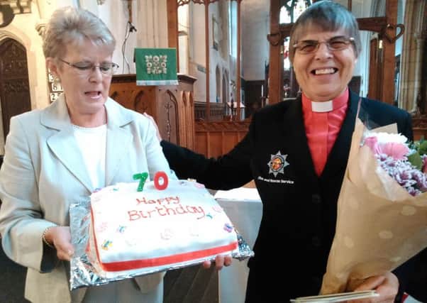 Eileen Tomlinson presents a 70th birthday cake to the Rev Barbara Johnson, assistant priest at St Mary's Church, Potton.